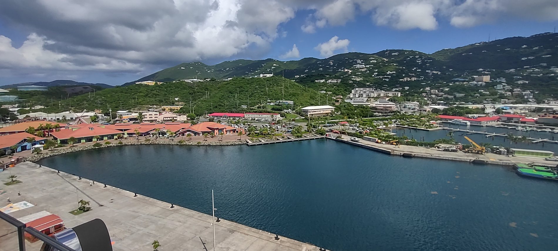 Wide view over Charlotte Amalie harbour in St. Thomas from a cruise ship, red roofs and green hills around the bay